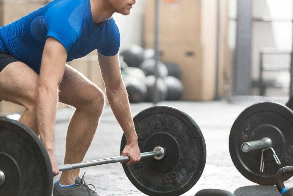 CrossFit athlete lifting barbell during WOD