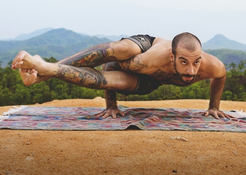 Man doing tough "Eka Pada Koundinyasana" exercise outdoors