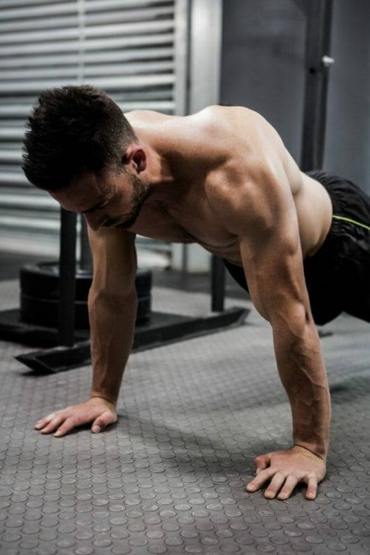 Shirtless man doing push up at the crossfit gym