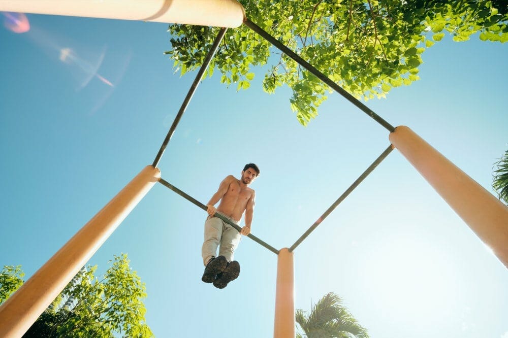 Man doing muscle-ups on outdoor bars