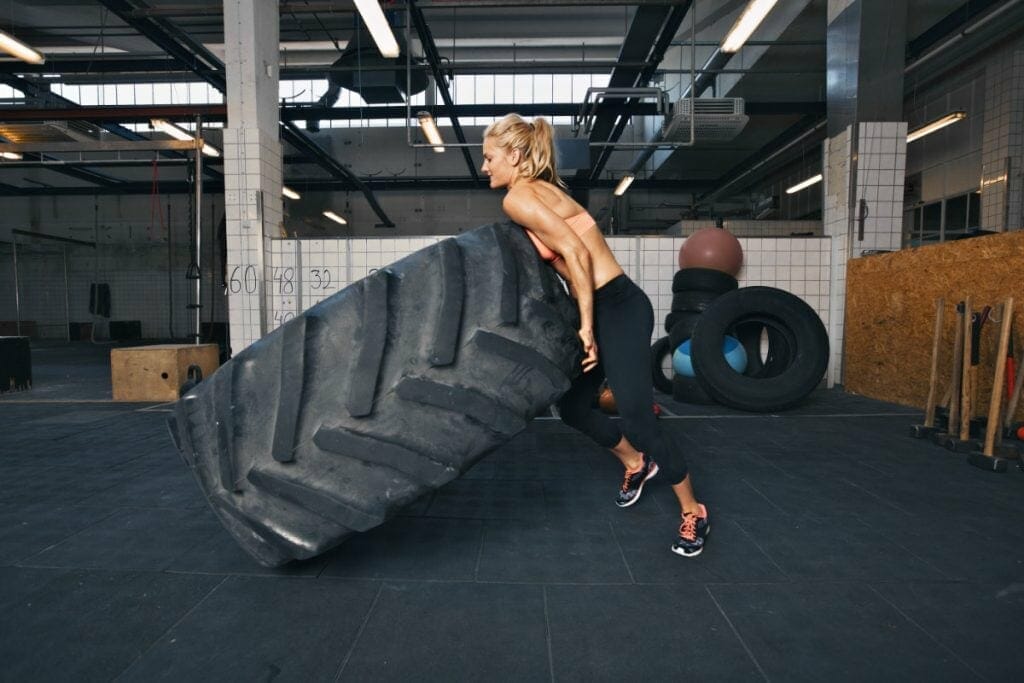 Fit Female Athlete Flipping A Huge Tire