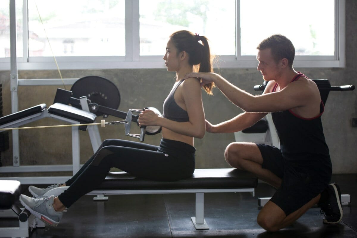 Personal Trainer With Client In Regular Gym