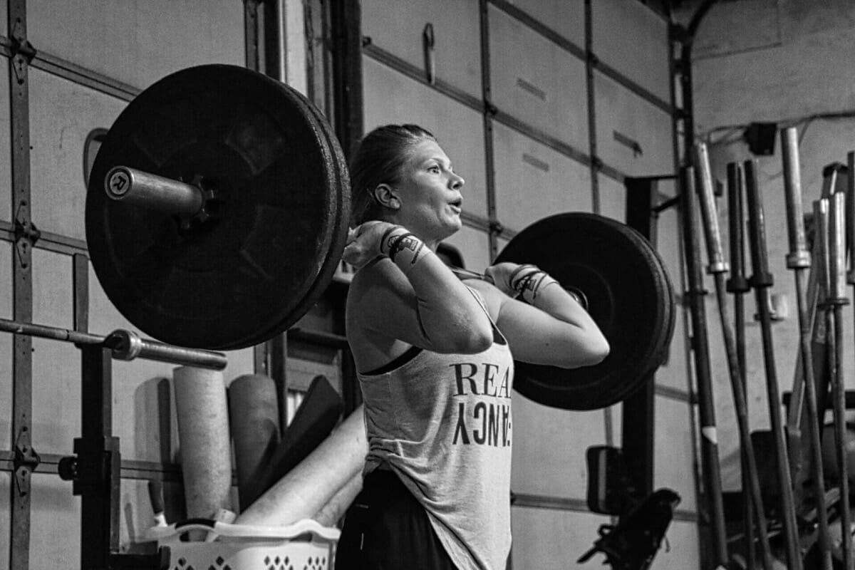 Female Crossfit Athlete Performing Clean With Wrist Straps