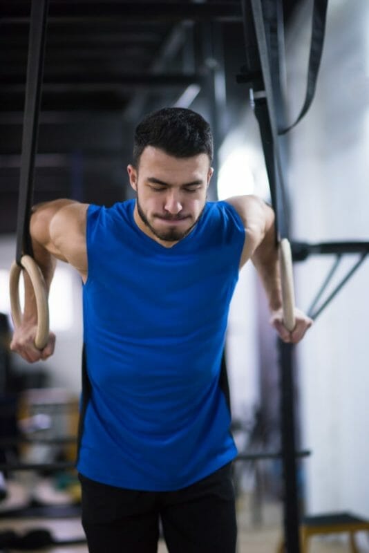 Man Working Out Pull Ups With Gymnastic Rings