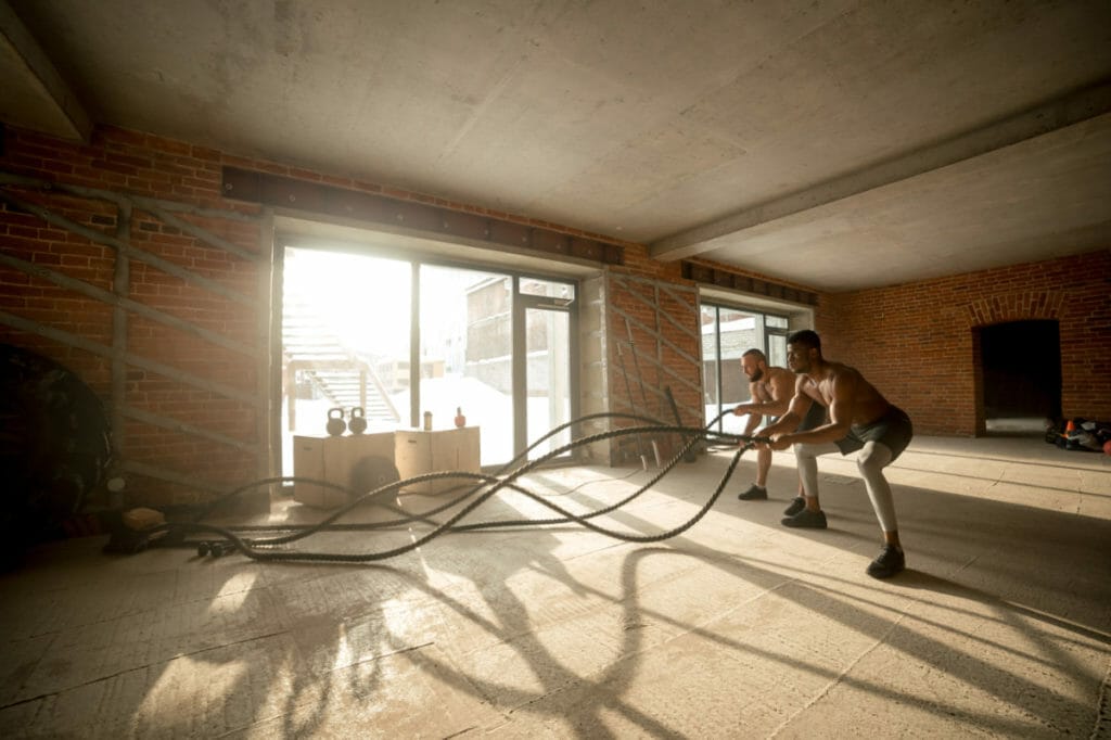 men using battle ropes to get fit at home